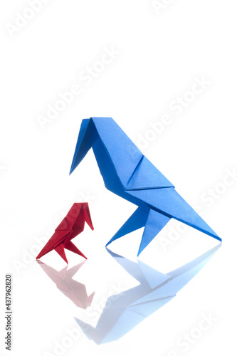 Origami bird made of colored paper isolated on white background. Family concept