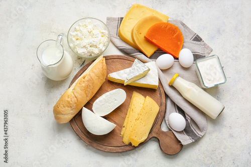 Different dairy products and chicken eggs on light background