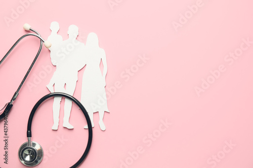 Family figures with stethoscope on color background