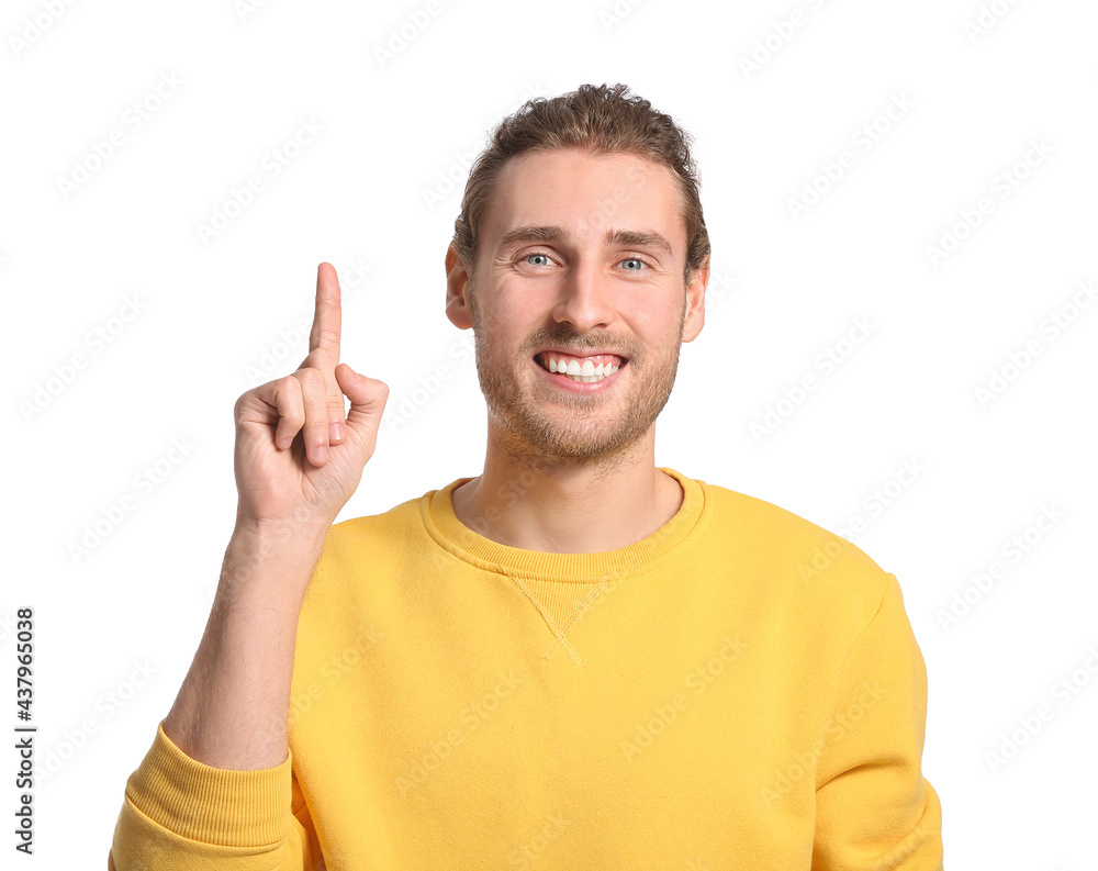 Handsome young man pointing at something on white background Handsome young man pointing at something on white background
