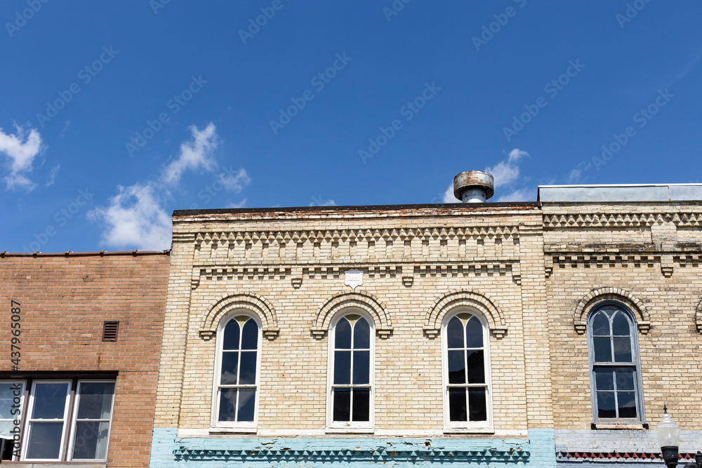 The cornice of an old, historic, brick building on a sunny day with a blue sky with copy space.