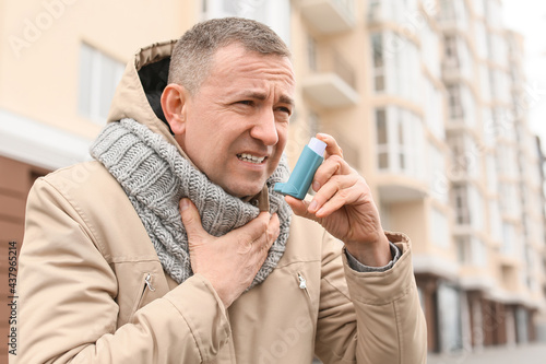 Senior man with inhaler hav...
