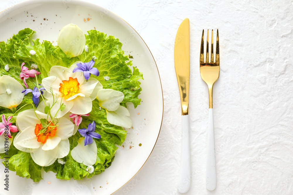 Plate with fresh lettuce and flowers on light background, closeup Plate with fresh lettuce and flowers on light background, closeup