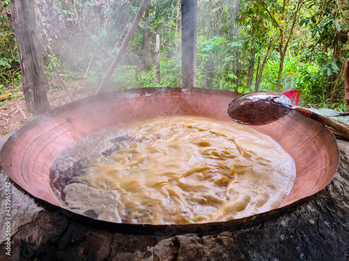Boiling the sugarcane juice to make garapa, sugar and cachaça in a copper pot, ( Rapadura ) photo