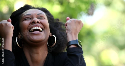 Ecstatic woman celebrating success and achievement, african black ethnicity photo