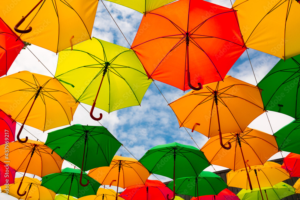 Nice yellow orange green and red color umbrella on blue sky