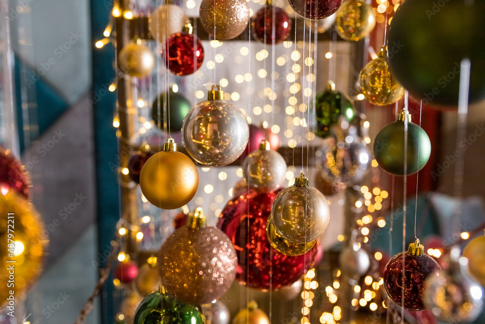 A group of Christmas balls hanging on thin threads on blurred background. Happy new year theme. greeting card.Colorful Christmas small balls hang on ribbons A group of Christmas balls hanging on thin threads on blurred background. Happy new year theme. greeting card.Colorful Christmas small balls hang on ribbons