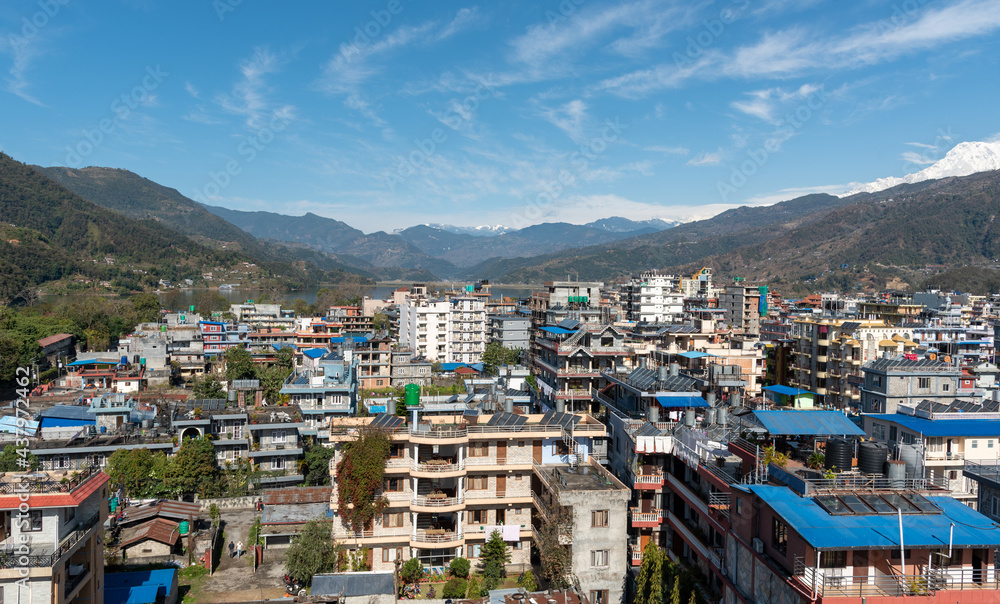 Cityscape of Pokhara with the Annapurna mountain range covered in snow at central Nepal, Asia