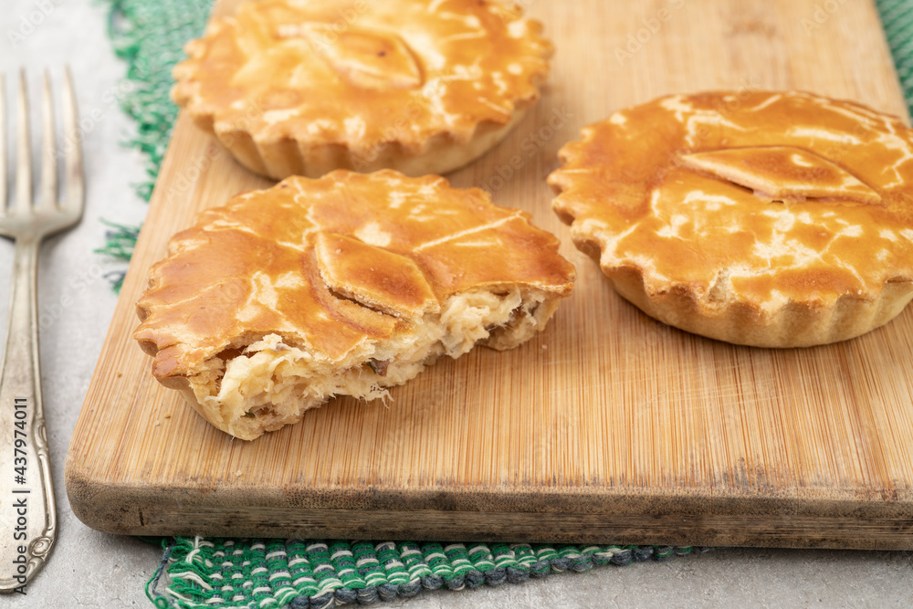Homemade chicken stuffed pies over wooden board Homemade chicken stuffed pies over wooden board