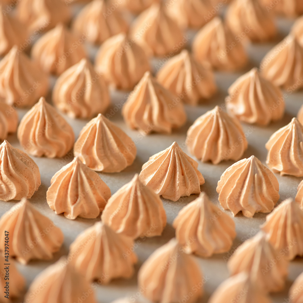 Group of orange meringues, close up shot. Airy sweets in form of drop, fresh from oven. Delicate dessert, egg sweets or Pastries. Food background. Soft focus. Group of orange meringues, close up shot. Airy sweets in form of drop, fresh from oven. Delicate dessert, egg sweets or Pastries. Food background. Soft focus.