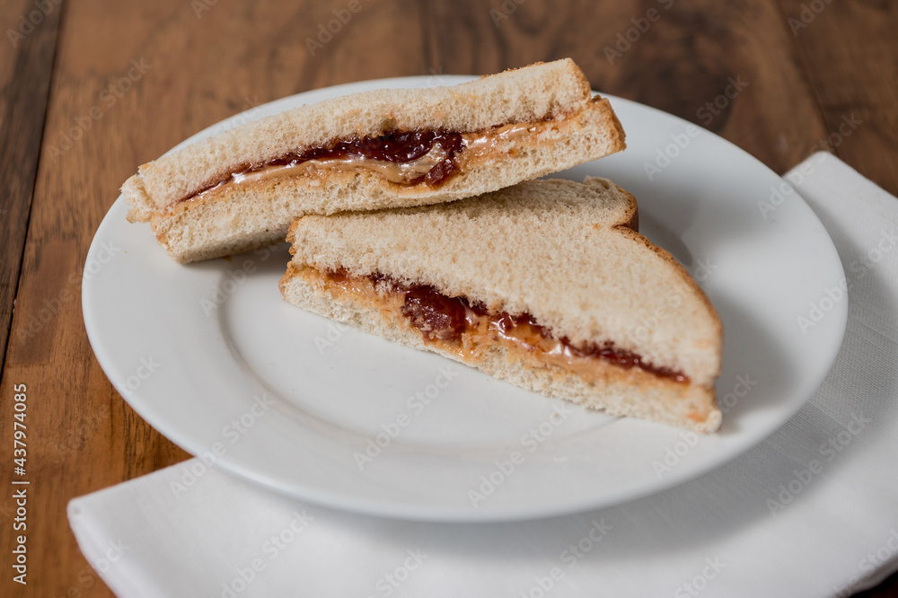 peanut butter and jelly sandwich triangles on white plate peanut butter and jelly sandwich triangles on white plate