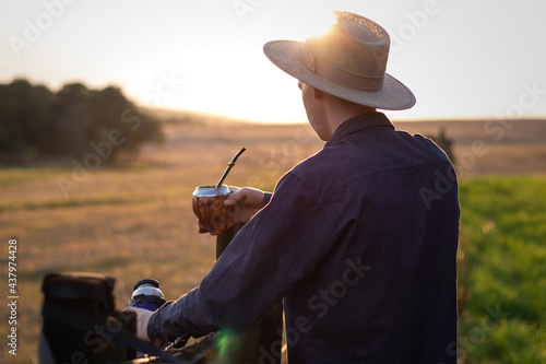 Gaúcho segurando chimarrão pôr do sol no pampa
