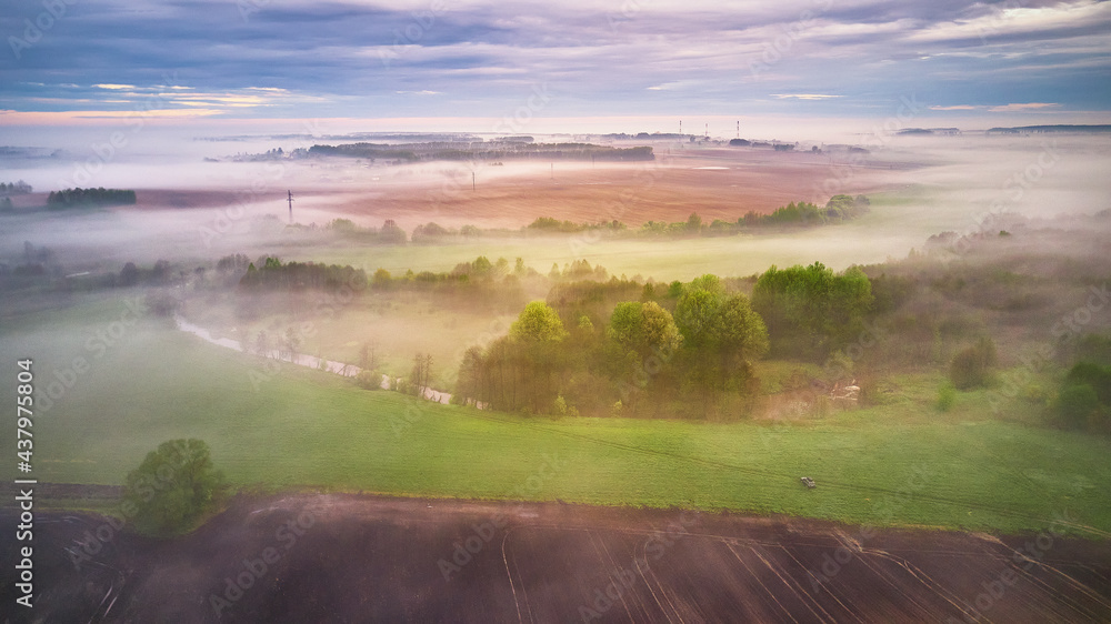 Summer cloudy rainy foggy morning panorama. Rural misty river, fields, meadow, village.