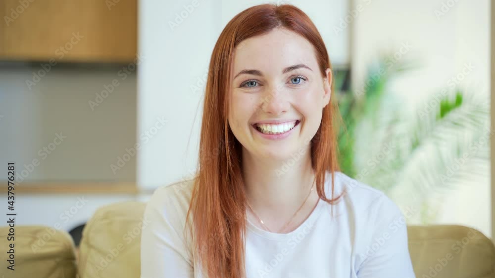Close-up portrait of a redhaired young happy girl or woman happily smiling in living room at home. Sincere and friendly red hair female looking at the camera indoors Satisfied Face Student White teeth Close-up portrait of a redhaired young happy girl or woman happily smiling in living room at home. Sincere and friendly red hair female looking at the camera indoors Satisfied Face Student White teeth