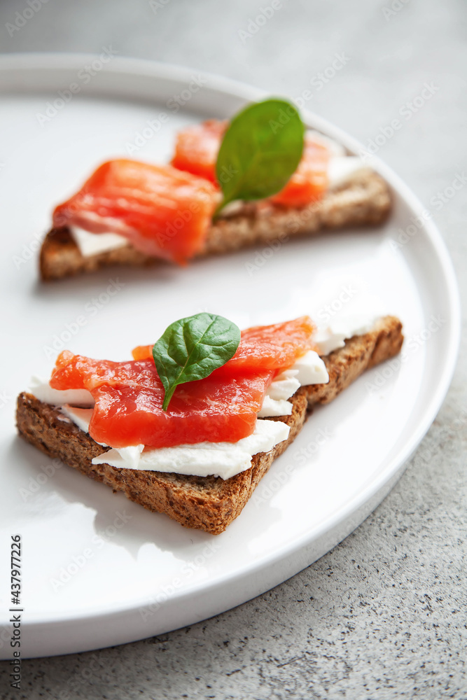 Bruschetta with red fish and cream cheese with black bread on white plate. Bruschetta with red fish and cream cheese with black bread on white plate.