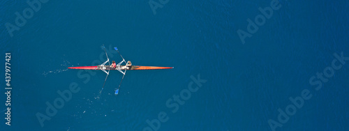 Aerial drone top ultra wide panoramic view of sport canoe rowing synchronous male athletes competing in deep blue sea