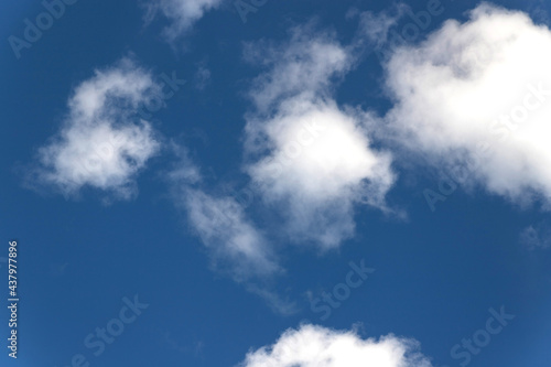 White clouds in a blue sky. The airiness and lightness of a summer morning. Natural phenomena. Sky background.