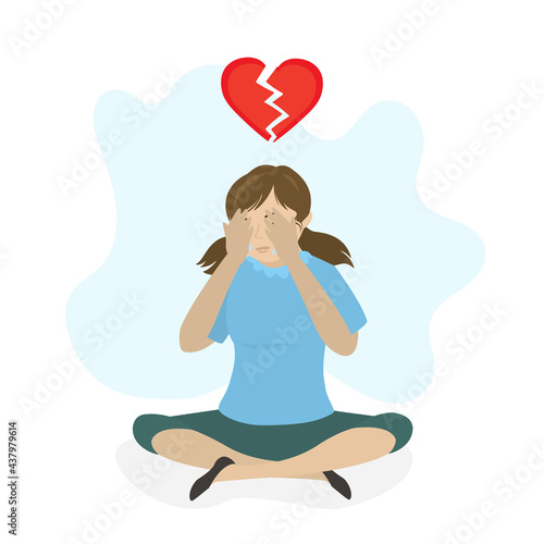 Girl teenager in depression after breakup. Caucasian schoolgirl sits and cries. Broken red heart. Negative emotions. Mental, psychological problems.