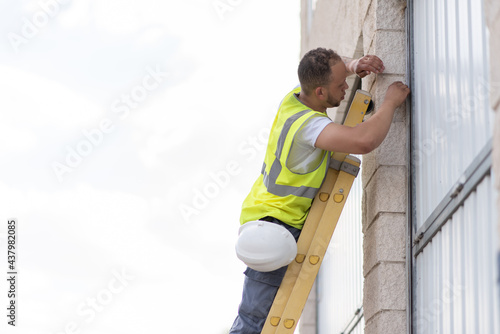 telecommunications technician working on a facade without safety helmet on
