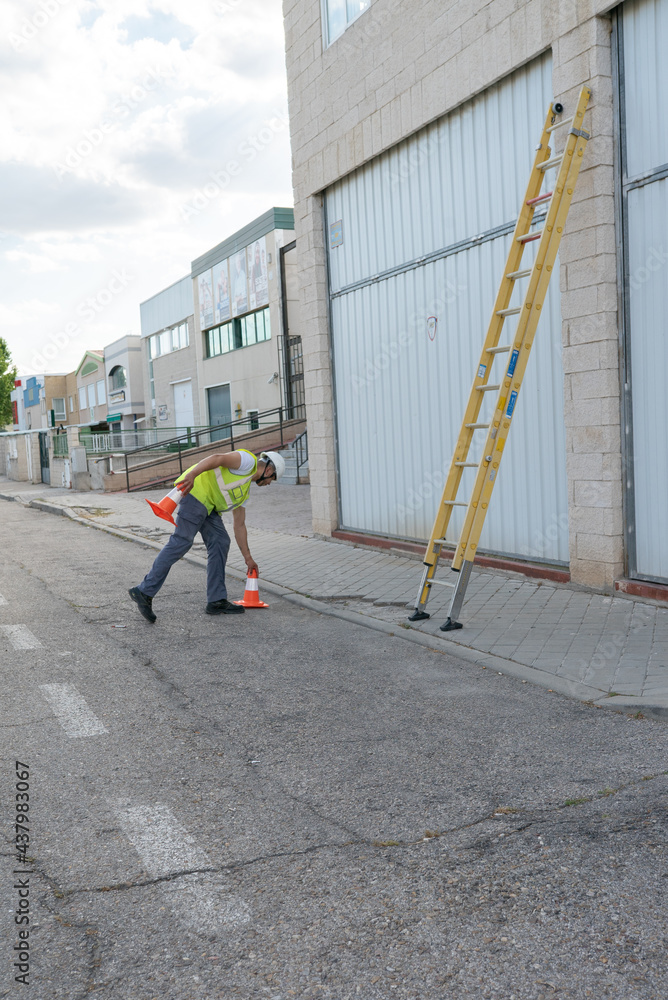 telecommunications technician placing security cones on the street