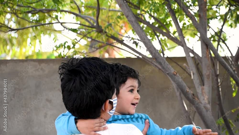 Portrait of wise Indian kid wearing mask while playing with younger brother. Concept of wearing mask during corona virus pandemic. Portrait of wise Indian kid wearing mask while playing with younger brother. Concept of wearing mask during corona virus pandemic.