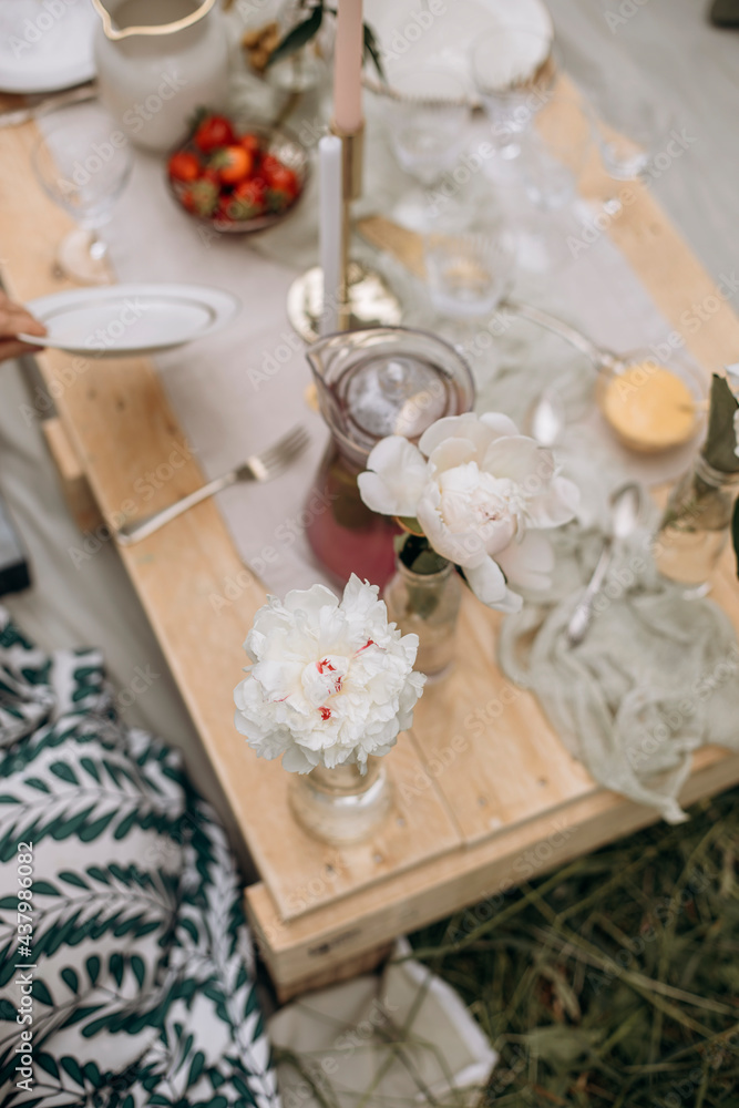 flower of white peonies in a vase on a wooden pallet table top view. peony-decorated table for outdoor parties.