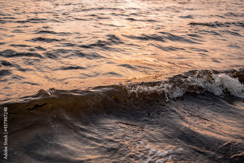 picture of the surface water in the sunset time. The texture of the river water at sunset.