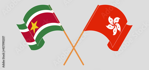 Crossed and waving flags of Suriname and Hong Kong