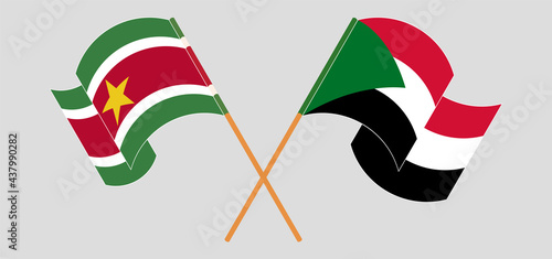 Crossed and waving flags of Suriname and the Sudan