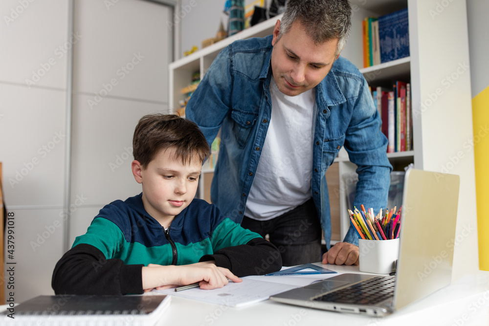 Father helping son finish homework Father helping son finish homework