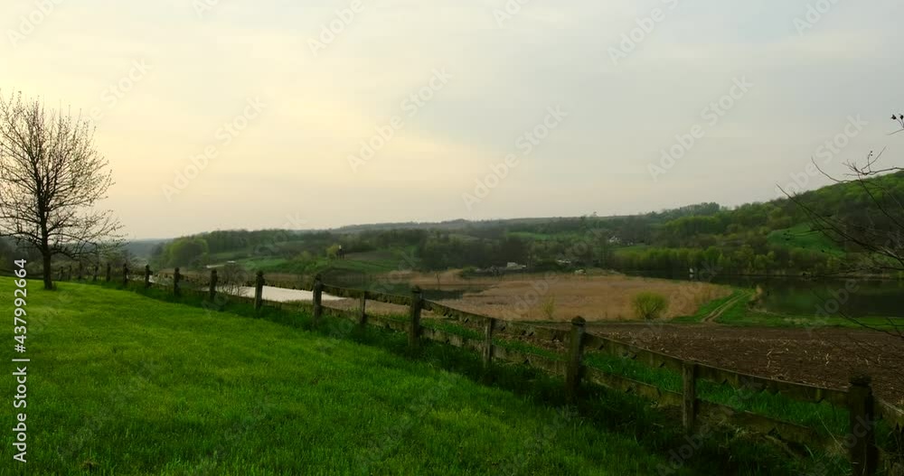 Green, spring field.field in the village.Sunrise .Green field and village on horizon. the small farm near by the road. Mountainous terrain and the blue sky Green, spring field.field in the village.Sunrise .Green field and village on horizon. the small farm near by the road. Mountainous terrain and the blue sky