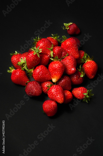 A slide of ripe red strawberries on a black background, close up.