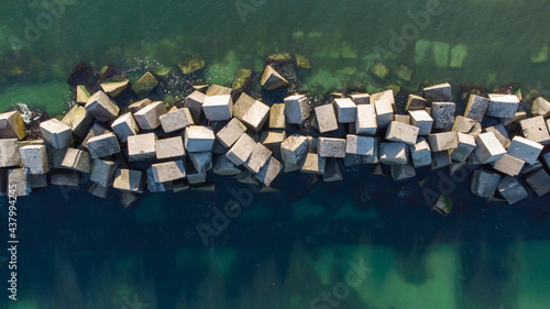 Принти на полотні A breakwater made of white concrete cubes and a leading sign at the entrance to the port of Yuzhny