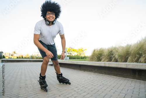 Latin man rollerskating outdoors.