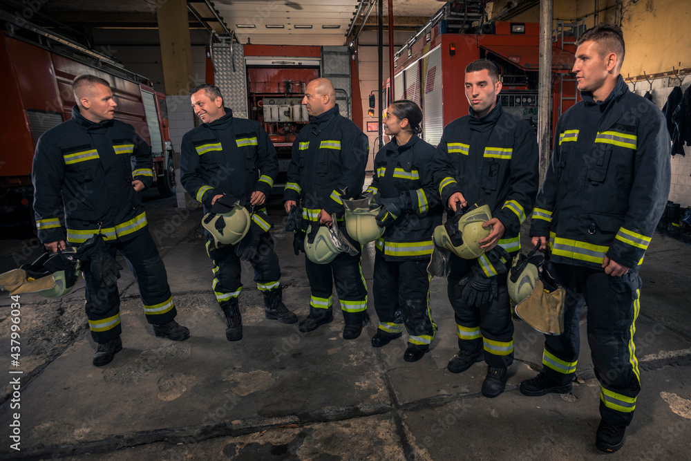 Portrait of firefighters standing by a fire engine. Portrait of firefighters standing by a fire engine.