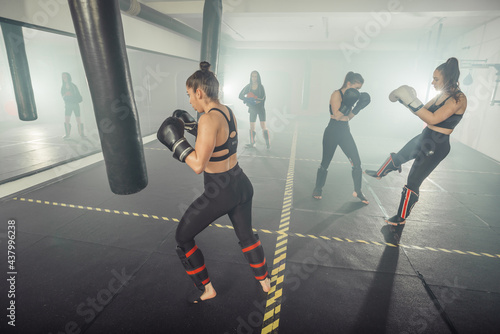 Boxer woman. Boxing fitness woman smiling happy wearing black boxing gloves. Portrait of sporty fit Asian model of boxing gym