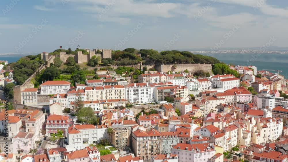 Aerial view of Castelo de S Jorge Lisbon castle on the hill above colorful traditional houses in urban city center of Lisbon, Portugal Aerial view of Castelo de S Jorge Lisbon castle on the hill above colorful traditional houses in urban city center of Lisbon, Portugal