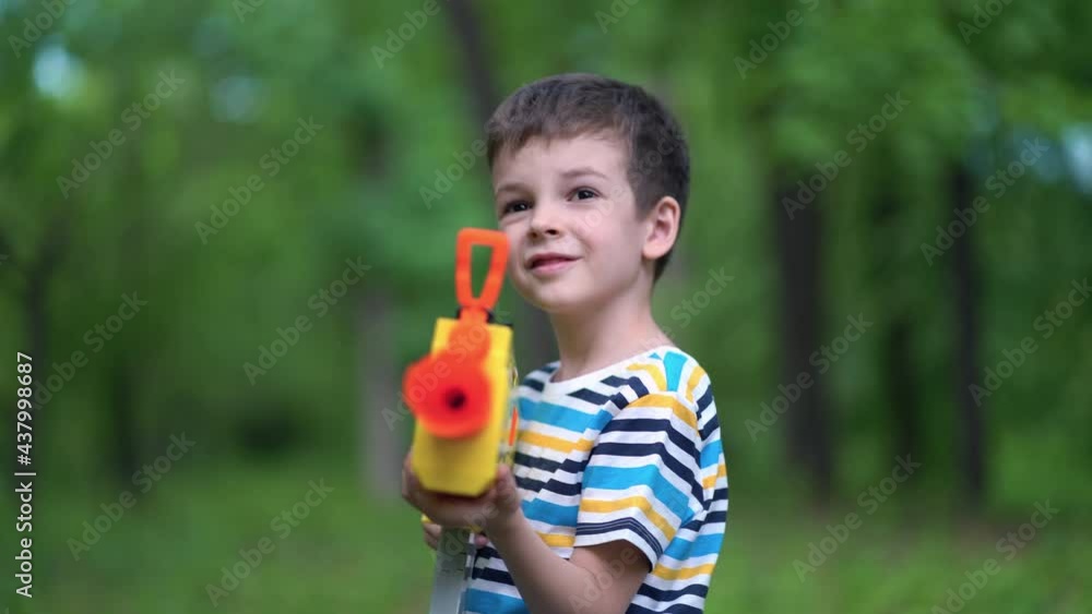Child boy shoots from toy weapons gun outdoors Child boy shoots from toy weapons gun outdoors