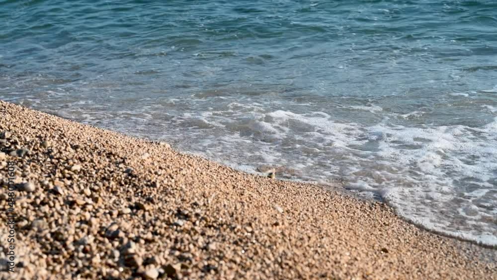Waves crushing on beach with yellow sand. Waves breaking on the shore. Coastline. Beautiful pebbles beach at summer. Waves crushing on beach with yellow sand. Waves breaking on the shore. Coastline. Beautiful pebbles beach at summer.