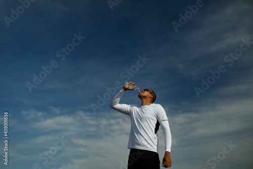 homem bebendo agua e fazendo exercícios ao ar livre 
