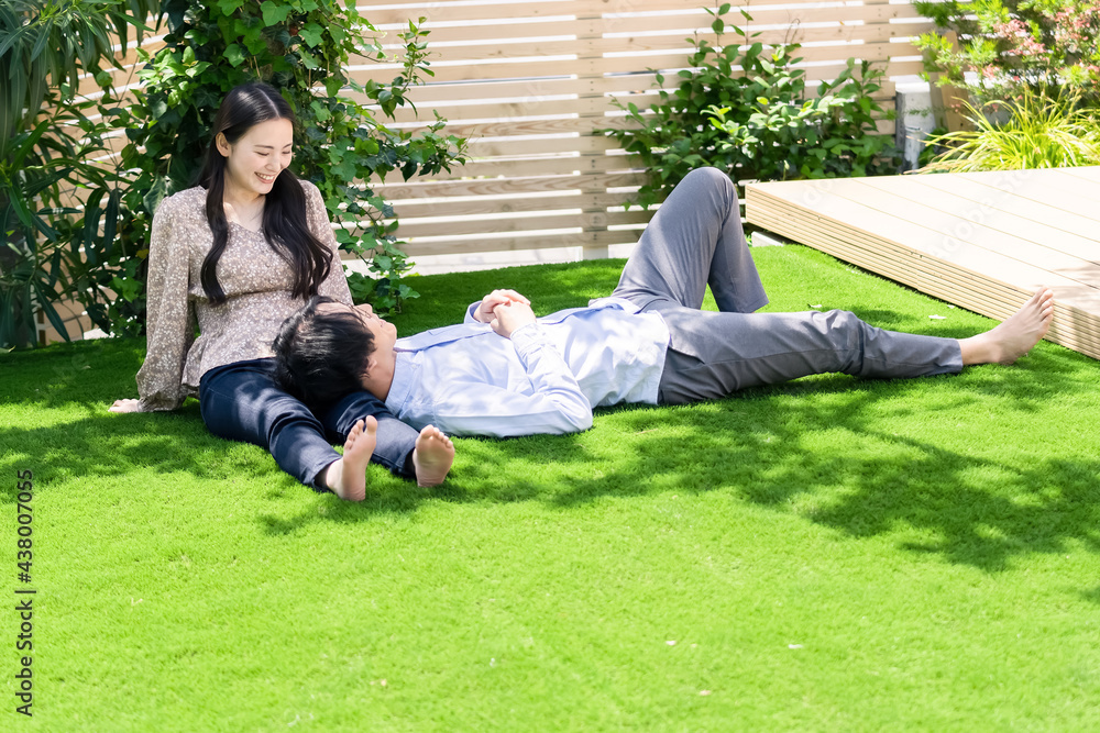 芝生で膝枕するカップル