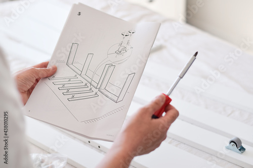 Woman reading an instruction manual to assemble furniture