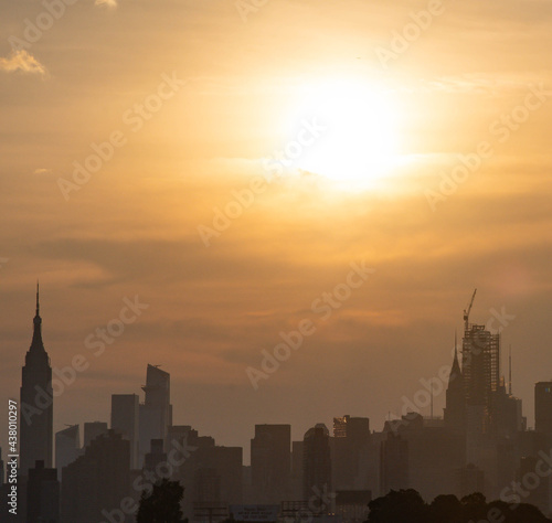sunset over the city silhouette skyline with vivid sun and sky 