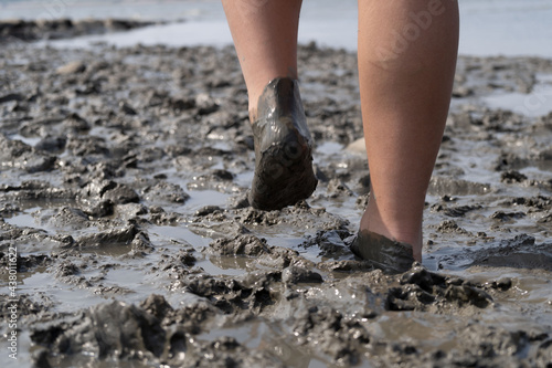 Girl bare foot on mudflat walking  photo