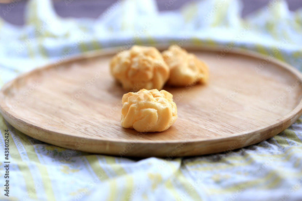 Fototapeta premium Choux cream, small fluffy creamy yummy vanilla inserted in round dessert as cold fresh sweet on wood plate.