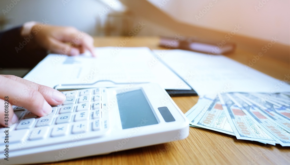 Businessman analyzing investment charts and pressing calculator buttons over documents. Accounting Concept. Businessman analyzing investment charts and pressing calculator buttons over documents. Accounting Concept.