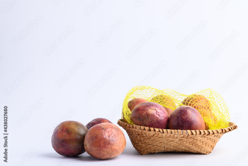 Obraz premium Fresh passion fruit in a basket on white background, Tropical fruit in summer season