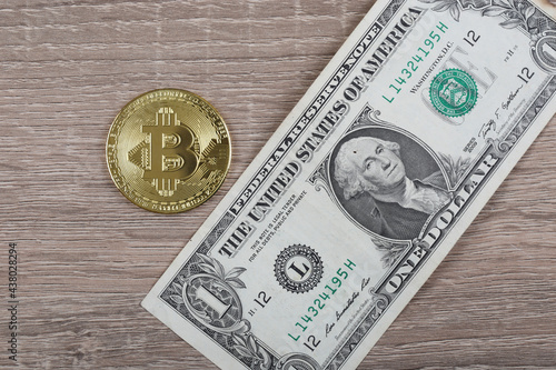 Bitcoin and US dollar over wooden background. Crypto concept