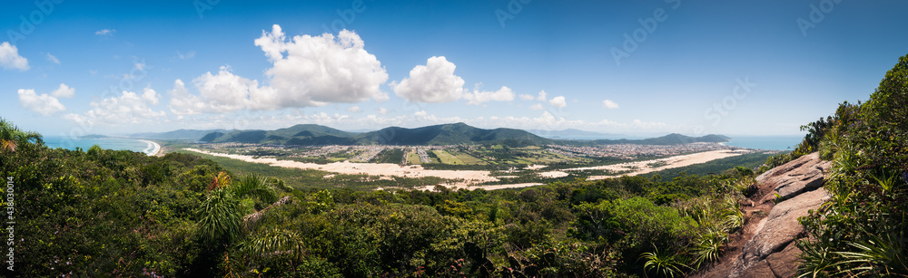 Ultra wide panoramic landscape of the Ingleses and Mocambique dunes on a wonderful sunny day at Florianopolis, blue sky and mountains in the background. View from the top of Morro das aranhas. 