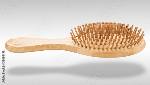 Massage hairbrush. Hairdresser Bamboo brush. Natural wooden comb. Professional equipment for beauty salon. Health for hair. Object on white isolated background. Close-up  Macro High resolution photo.